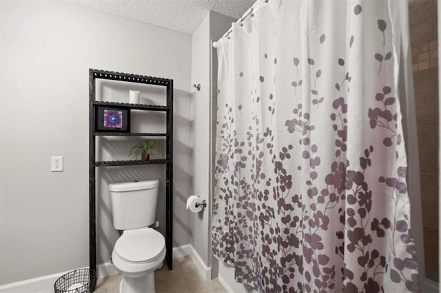 bathroom with baseboards, tile patterned flooring, toilet, and a textured ceiling