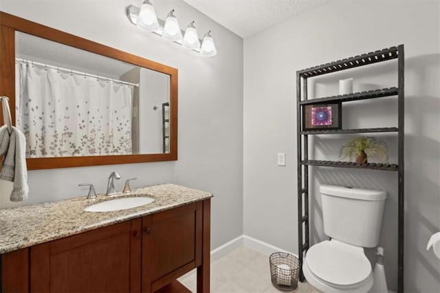 bathroom featuring vanity, toilet, a textured ceiling, tile patterned floors, and baseboards