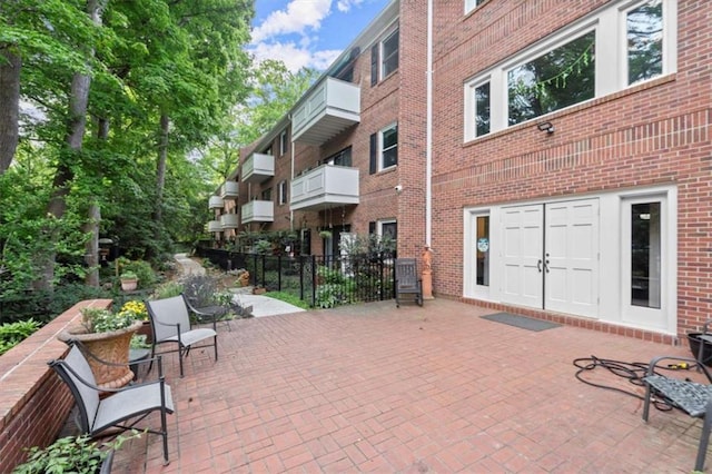 view of property's community featuring fence and a patio