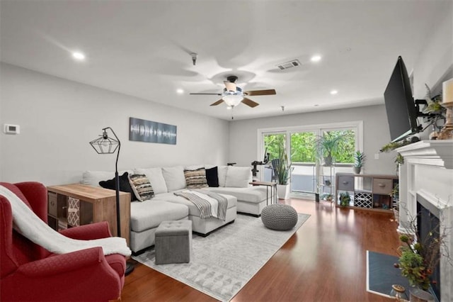 living room with a ceiling fan, recessed lighting, a fireplace with flush hearth, wood finished floors, and visible vents