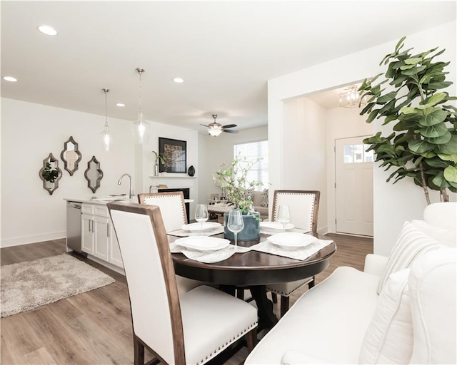 dining area featuring recessed lighting, a fireplace, and wood finished floors