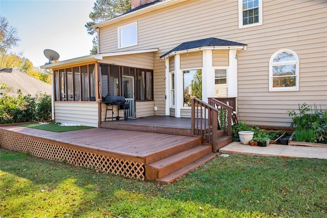 rear view of property with a deck, a sunroom, and a lawn