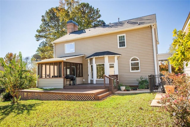 back of house featuring a wooden deck, a yard, and a sunroom