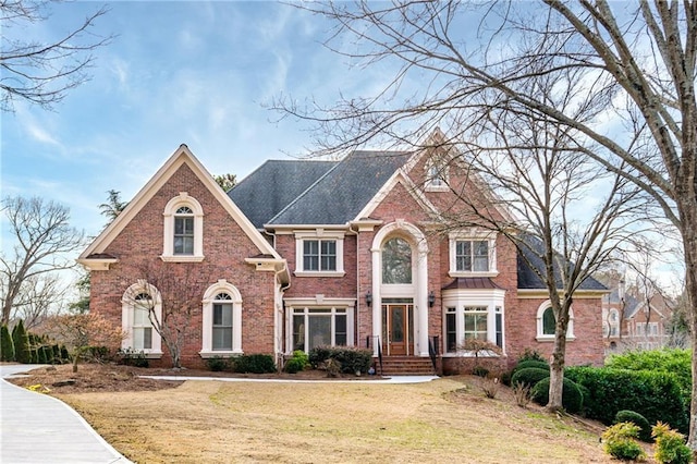 traditional-style home with a front lawn and brick siding