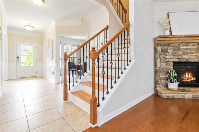 441 Spring View Dr, Woodstock, GA 30188 - foyer entrance with stairway, a stone fireplace, crown molding, a wainscoted wall, and a decorative wall