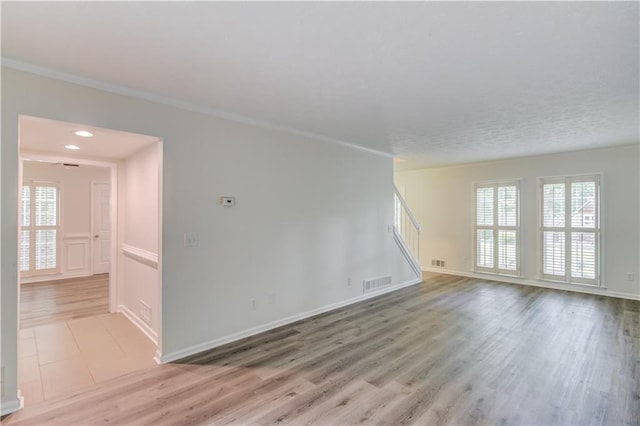 6006 Lanier Heights Cir, Buford, GA 30518 - unfurnished living room featuring stairs, light wood-style floors, baseboards, and crown molding