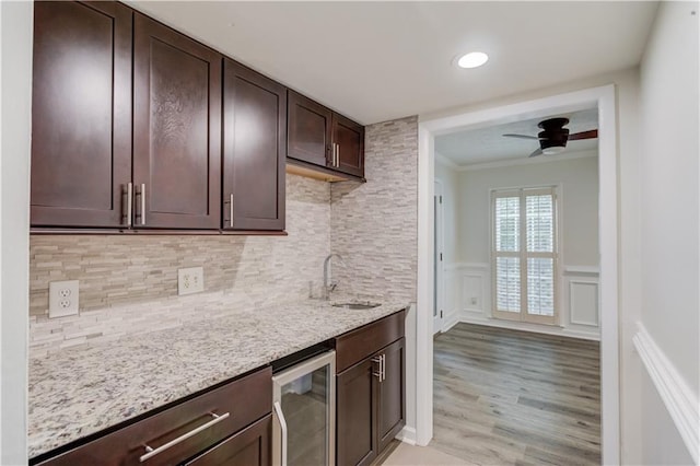 6006 Lanier Heights Cir, Buford, GA 30518 - kitchen with wine cooler, a sink, crown molding, a ceiling fan, and dark brown cabinetry