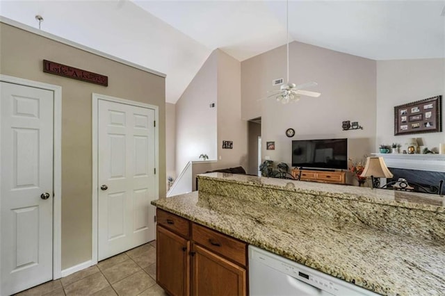 kitchen with lofted ceiling, light stone countertops, light tile patterned floors, and ceiling fan