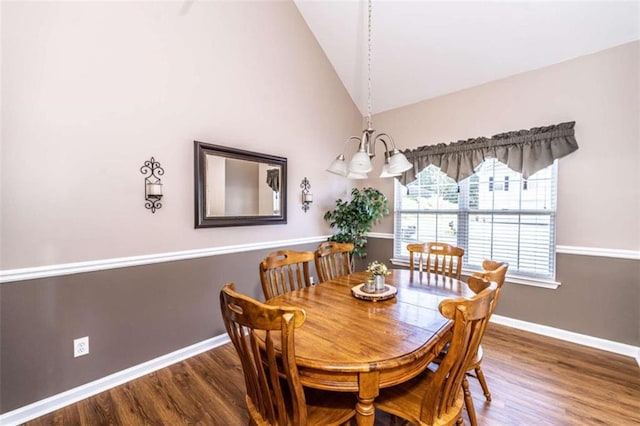 dining area featuring an inviting chandelier, hardwood / wood-style flooring, and high vaulted ceiling