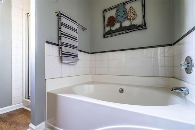 bathroom with wood-type flooring and independent shower and bath