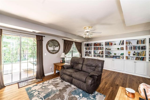 living room with a wealth of natural light, wood-type flooring, and ceiling fan