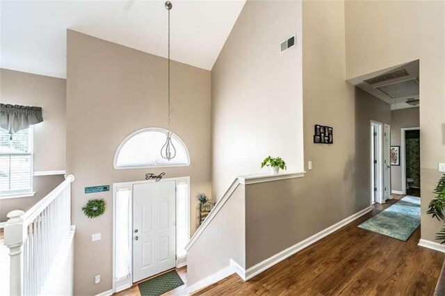 entrance foyer with dark hardwood / wood-style floors and high vaulted ceiling