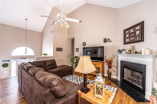 living room with ceiling fan, dark wood-type flooring, and high vaulted ceiling