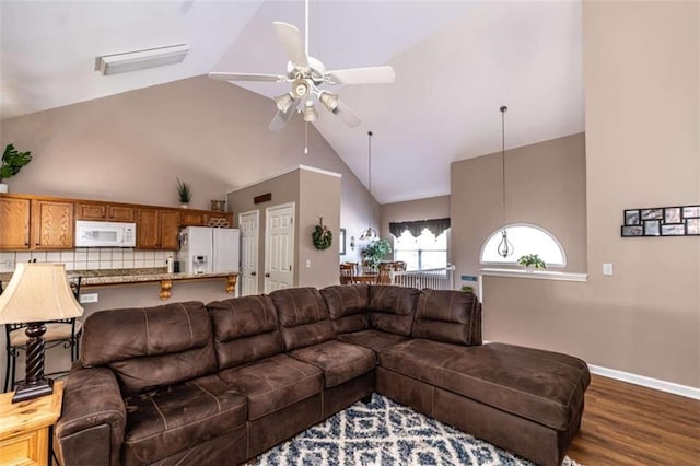 living room featuring ceiling fan, dark hardwood / wood-style floors, and high vaulted ceiling