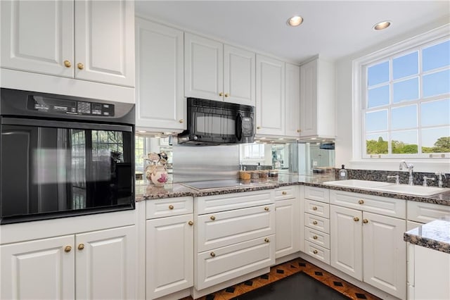 1325 Peachtree St NE Unit 401, Atlanta, GA 30309 - kitchen featuring a sink, dark stone countertops, white cabinetry, recessed lighting, and black appliances