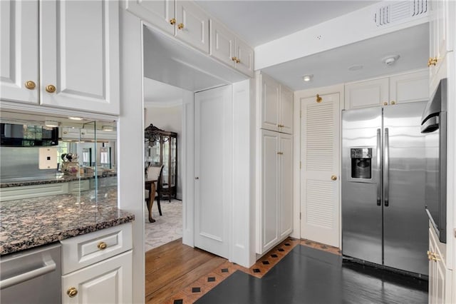 1325 Peachtree St NE Unit 401, Atlanta, GA 30309 - kitchen with visible vents, appliances with stainless steel finishes, dark stone countertops, light wood-style floors, and white cabinetry
