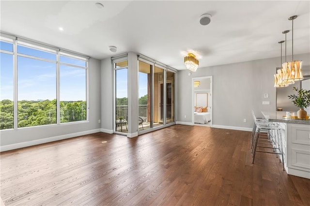 1820 Peachtree St NW Unit 804, Atlanta, GA 30309 - unfurnished living room featuring dark wood-style flooring, healthy amount of natural light, and a chandelier
