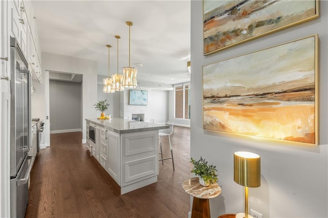 1820 Peachtree St NW Unit 804, Atlanta, GA 30309 - kitchen with white cabinets, dark wood finished floors, built in appliances, and a breakfast bar area