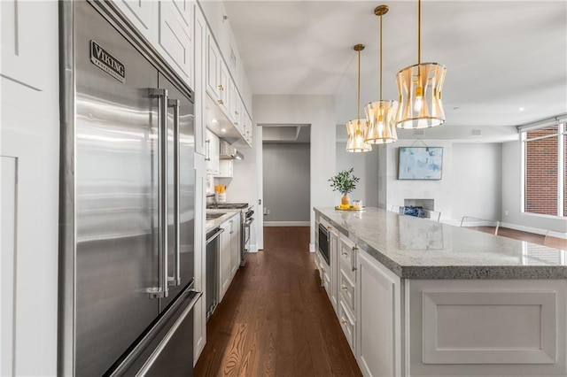 1820 Peachtree St NW Unit 804, Atlanta, GA 30309 - kitchen featuring built in appliances, dark wood-style floors, a kitchen island, and white cabinetry