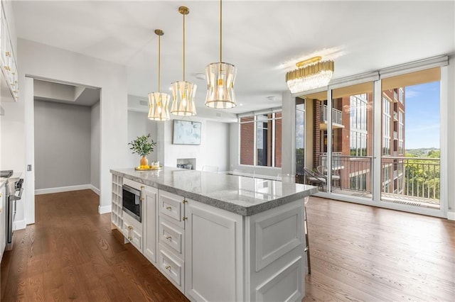 1820 Peachtree St NW Unit 804, Atlanta, GA 30309 - kitchen featuring dark wood-style flooring, stainless steel microwave, white cabinets, light stone countertops, and a wall of windows