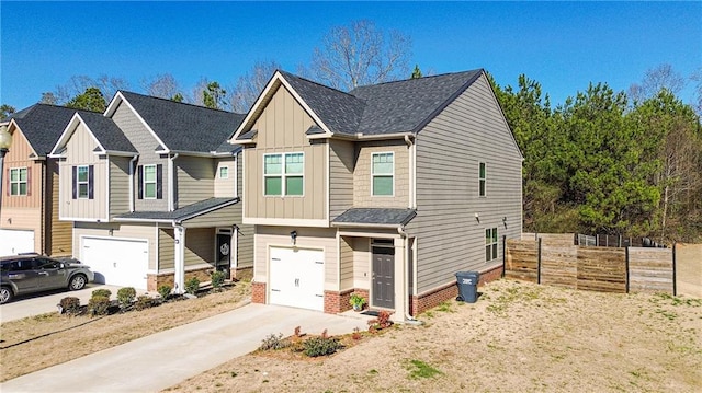 view of front of home with concrete driveway, an attached garage, fence, board and batten siding, and brick siding