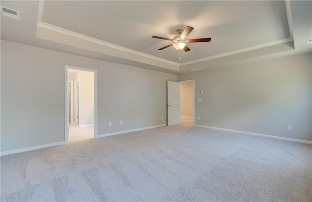 carpeted empty room featuring a raised ceiling and ceiling fan