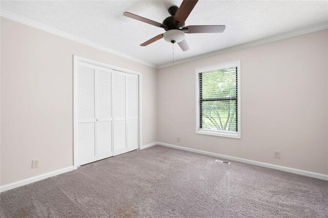 1140 Reading Dr NW, Acworth, GA 30102 - unfurnished bedroom featuring crown molding, carpet flooring, a closet, a ceiling fan, and a textured ceiling