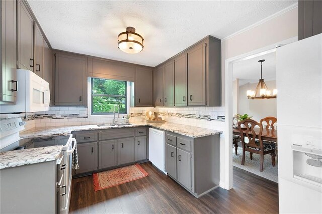 1140 Reading Dr NW, Acworth, GA 30102 - kitchen featuring white appliances, dark wood finished floors, a chandelier, tasteful backsplash, and a textured ceiling