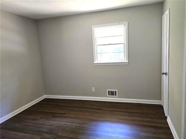 unfurnished room with dark wood-type flooring