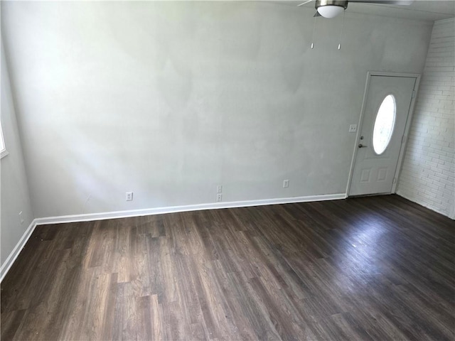 entrance foyer with dark hardwood / wood-style floors, ceiling fan, and brick wall