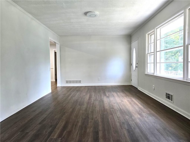 spare room featuring ornamental molding and dark hardwood / wood-style floors