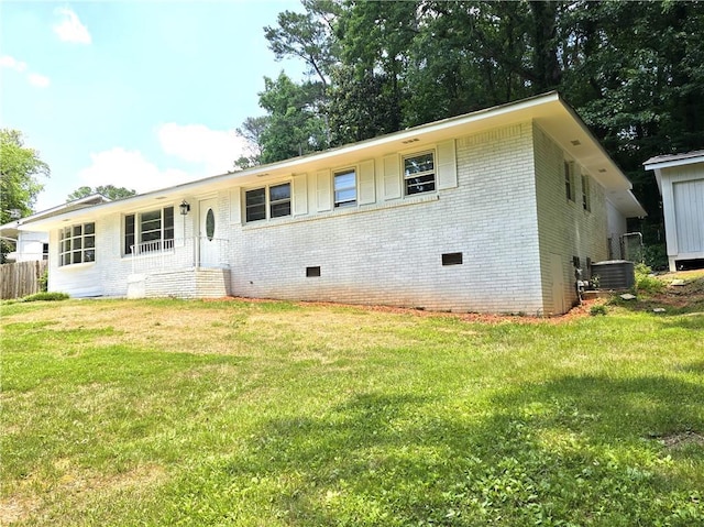 view of front facade with cooling unit and a front lawn