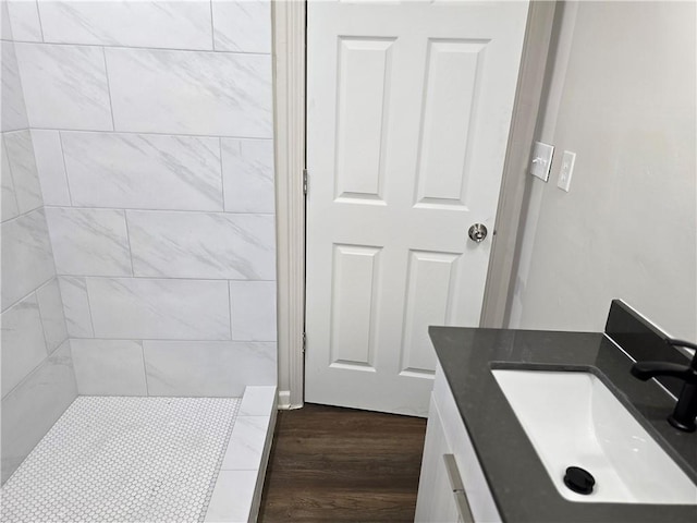 bathroom with vanity, wood-type flooring, and a tile shower