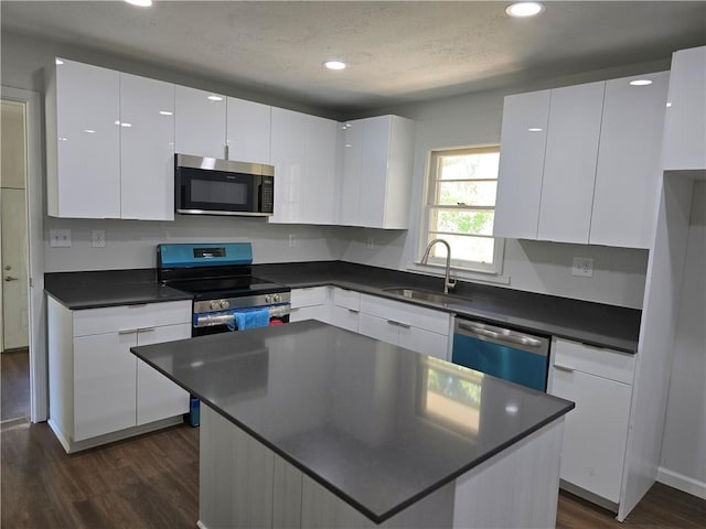 kitchen with white cabinetry, appliances with stainless steel finishes, sink, and dark wood-type flooring