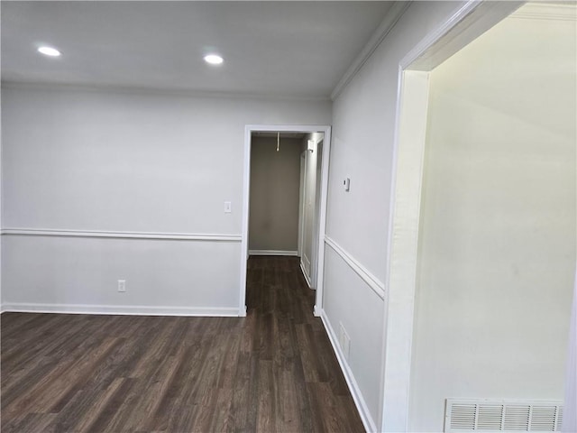 empty room with ornamental molding and dark hardwood / wood-style floors