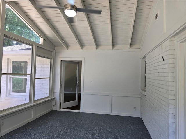 unfurnished room with ceiling fan and vaulted ceiling with beams