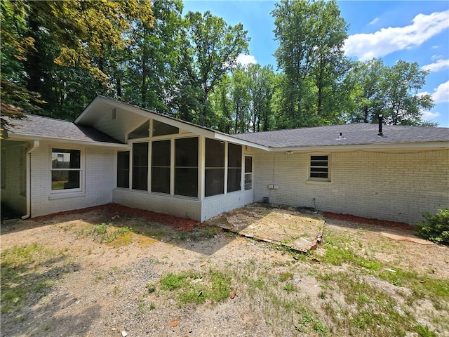 back of property with a sunroom