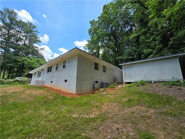 view of side of property featuring a yard and central AC