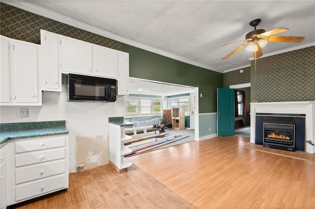 kitchen with ornamental molding, a textured ceiling, ceiling fan, light hardwood / wood-style flooring, and white cabinetry