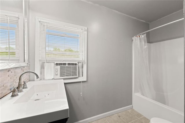 full bathroom featuring tile patterned floors, shower / bath combination with curtain, plenty of natural light, and sink