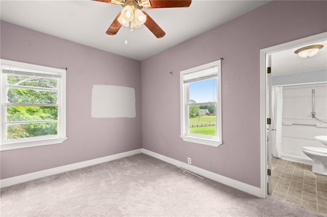 interior space featuring a wealth of natural light, light colored carpet, and ceiling fan