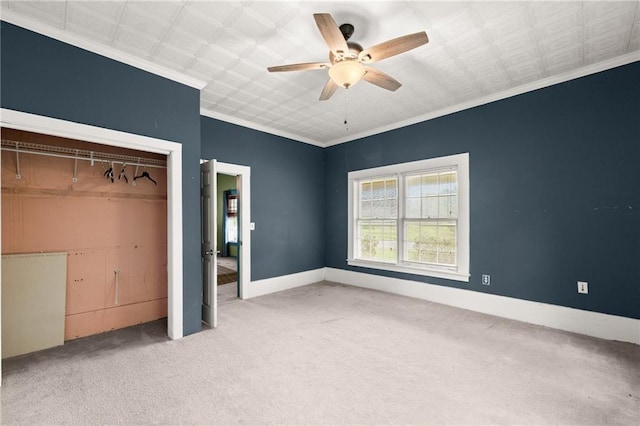 unfurnished bedroom with a closet, ceiling fan, crown molding, and carpet