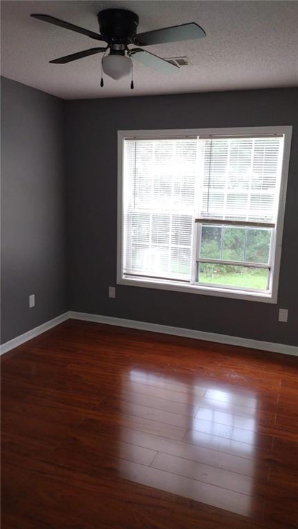 unfurnished living room featuring vaulted ceiling, hardwood / wood-style floors, and a tiled fireplace