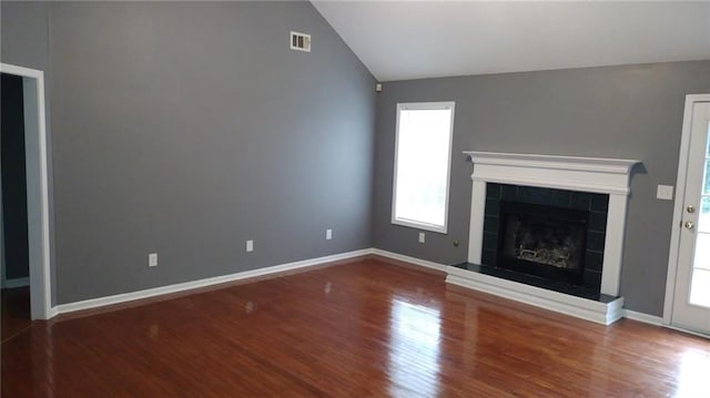 unfurnished living room featuring vaulted ceiling, a fireplace, and wood-type flooring