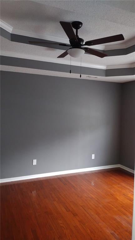 empty room featuring ceiling fan, wood-type flooring, crown molding, and a textured ceiling