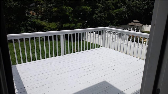 wooden terrace with a gazebo and a yard