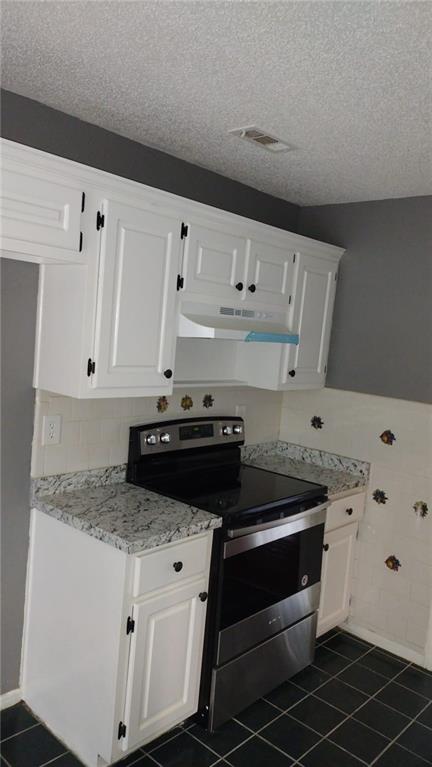 kitchen featuring light stone countertops, a textured ceiling, white cabinets, and stainless steel range with electric cooktop