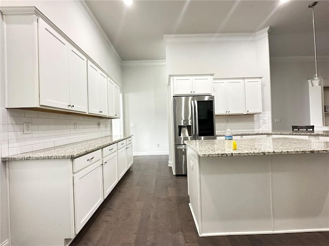 kitchen featuring dark hardwood / wood-style flooring, light stone countertops, stainless steel refrigerator with ice dispenser, hanging light fixtures, and white cabinets