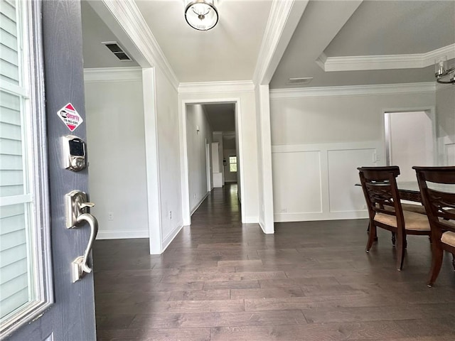 foyer entrance with crown molding and dark hardwood / wood-style flooring