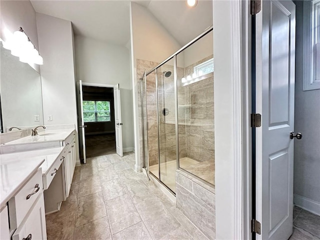 bathroom featuring walk in shower, vanity, lofted ceiling, and plenty of natural light